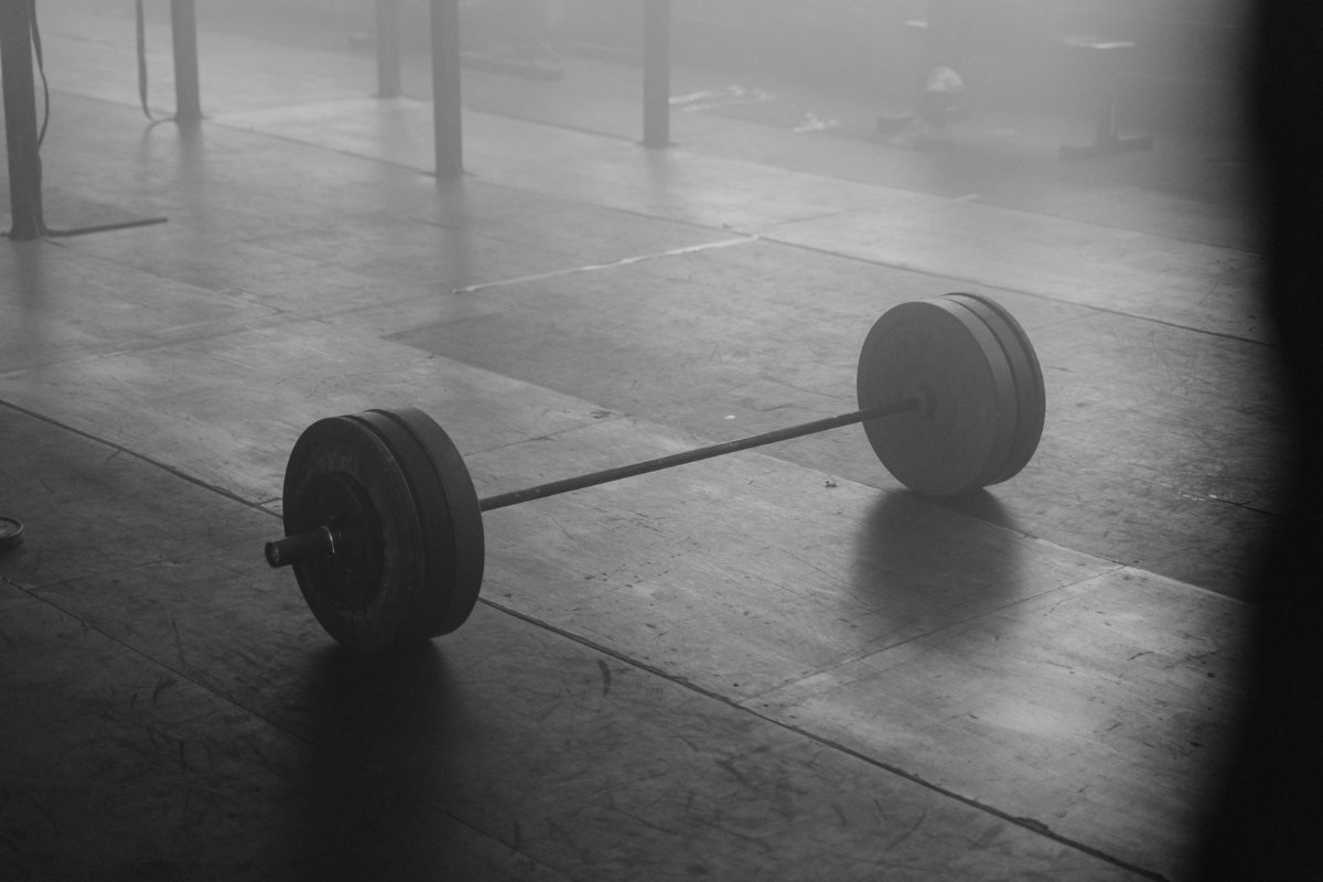 A black-and-white barbell resting on a gym floor.